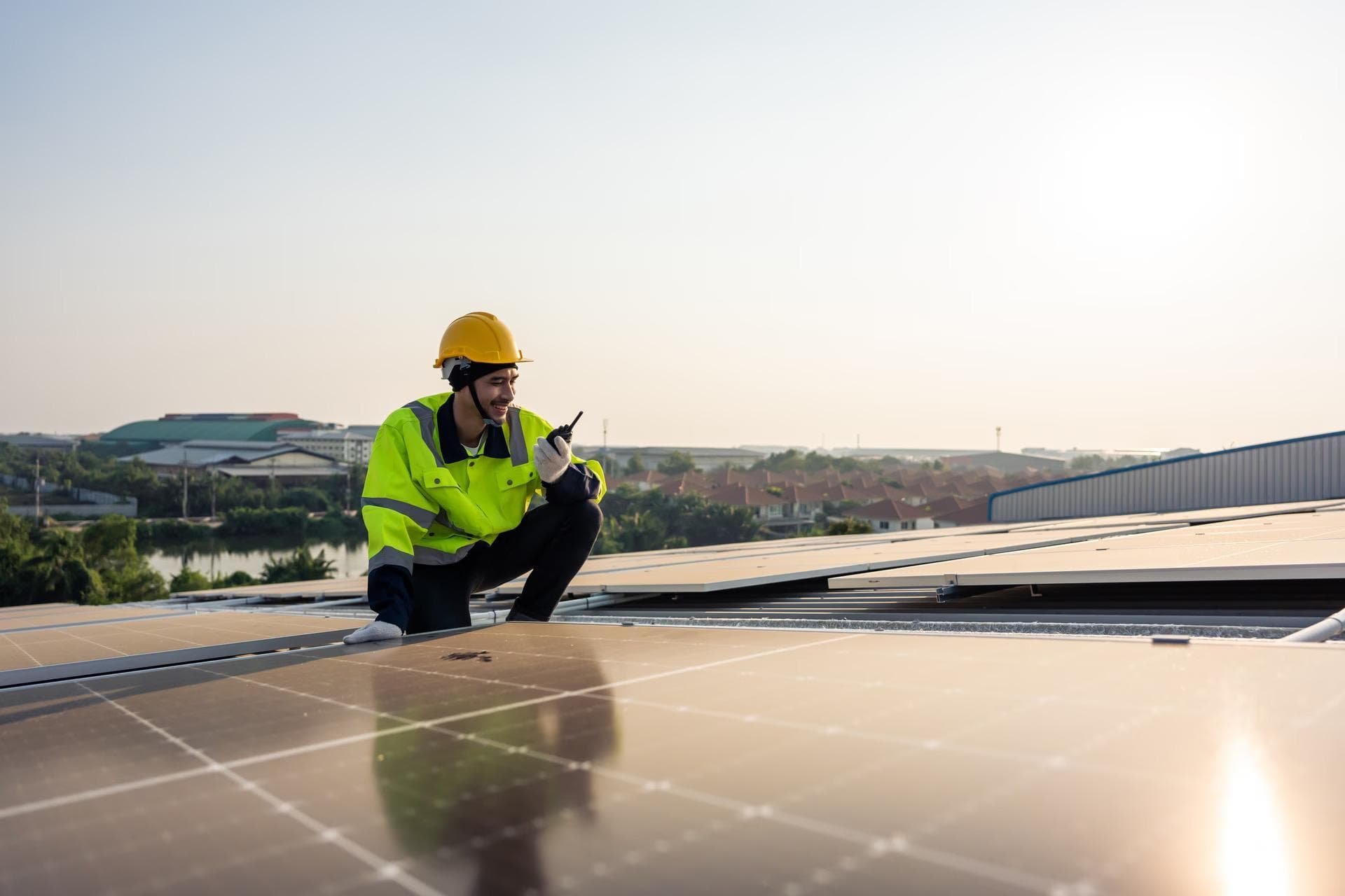 Arbeiter überprüft Solarpanels auf Dach