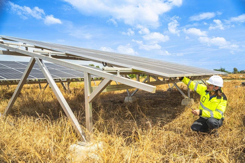 Ingenieur mit Sicherheitsausrüstung inspiziert großes Solarpanel