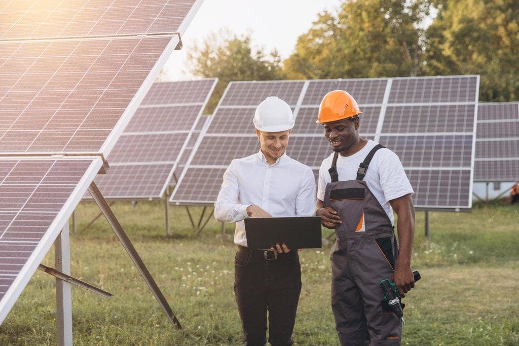 Fachkräfte überprüfen Solarpanels auf Solarstrom-Farm