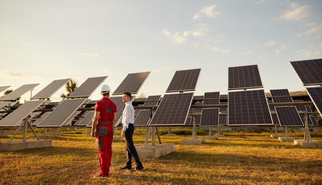 Manager und Arbeiter besprechen Solarenergie auf Solarfarm