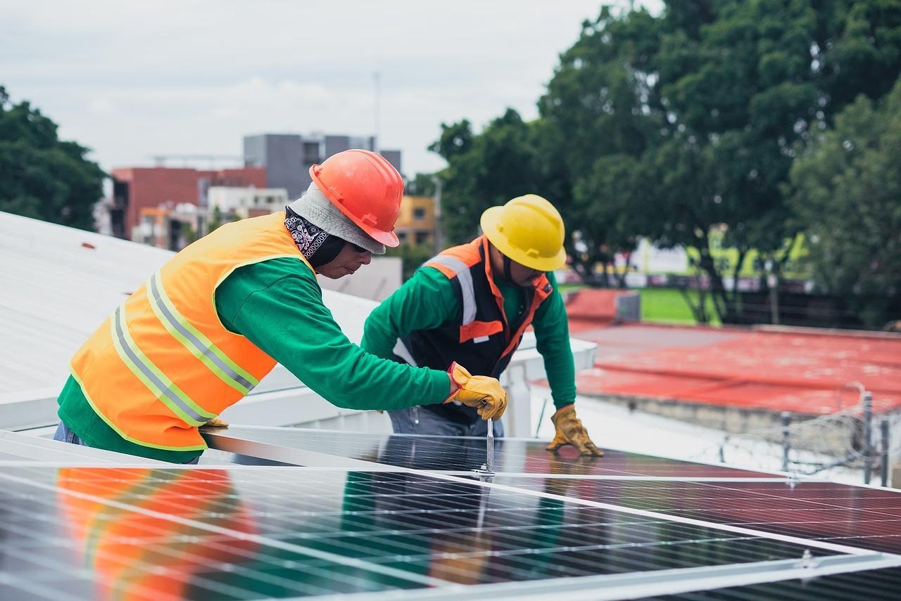 Photovoltaik Team montiert Solarpanels auf Dach für erneuerbare Energie