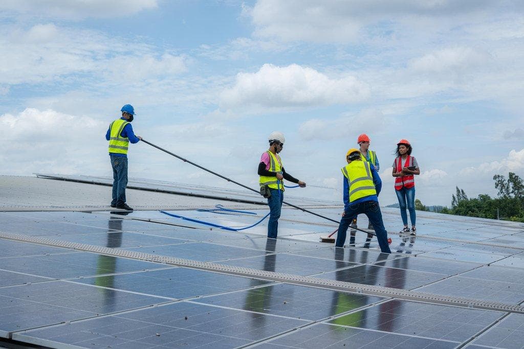 Arbeiter reinigt Solarpanels für maximale Energieeffizienz